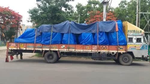 Loaded truck covered with blue tarpaulin